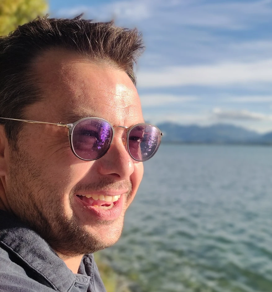 Anthony, your French teacher, smiling by a lake